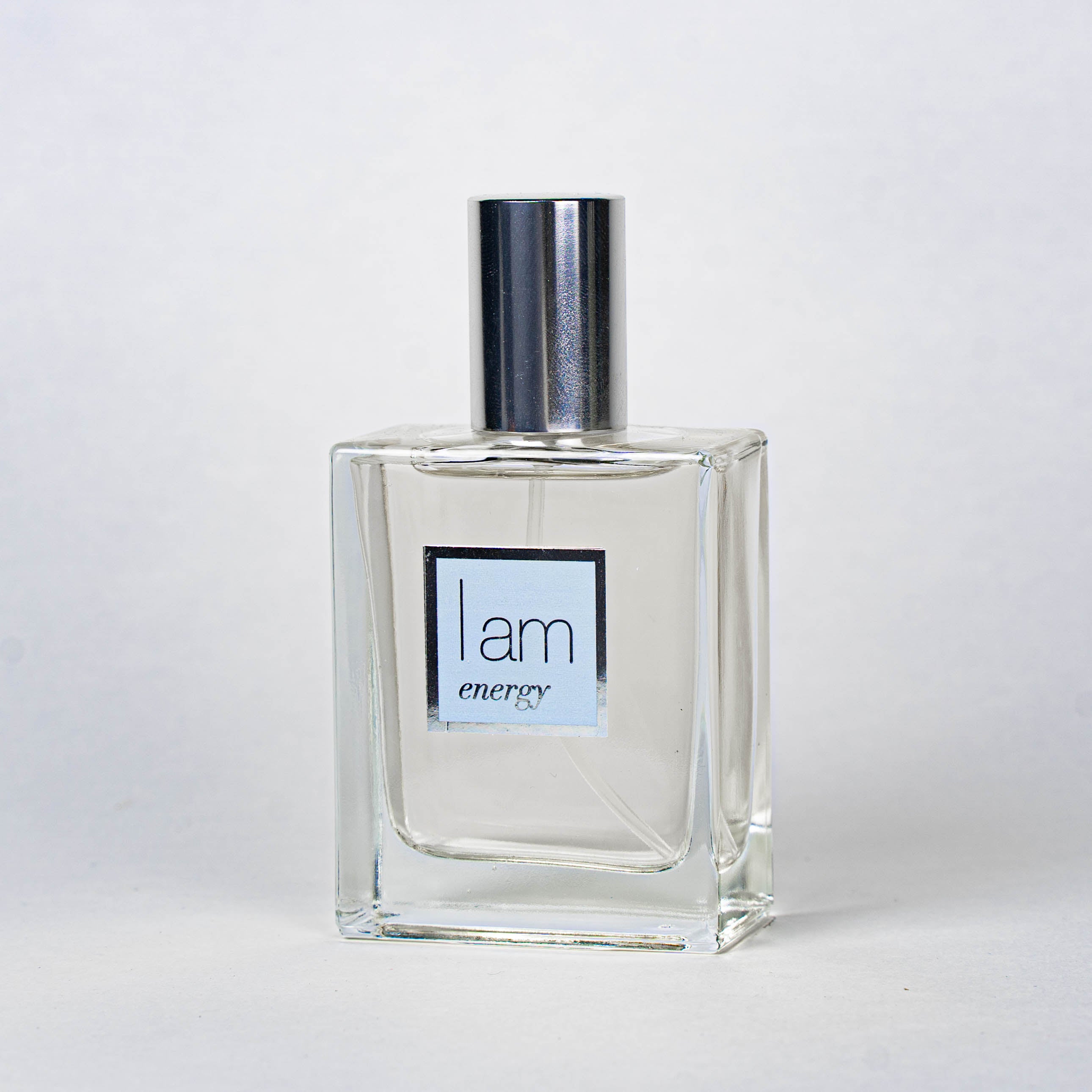 Clear perfume bottle with silver cap on a white background