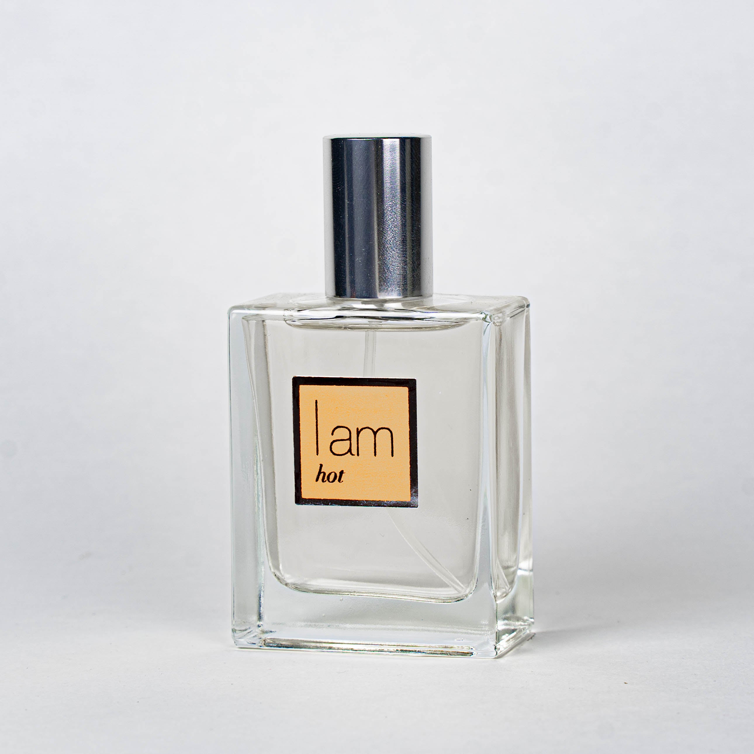 Clear perfume bottle with a metallic cap on a white background