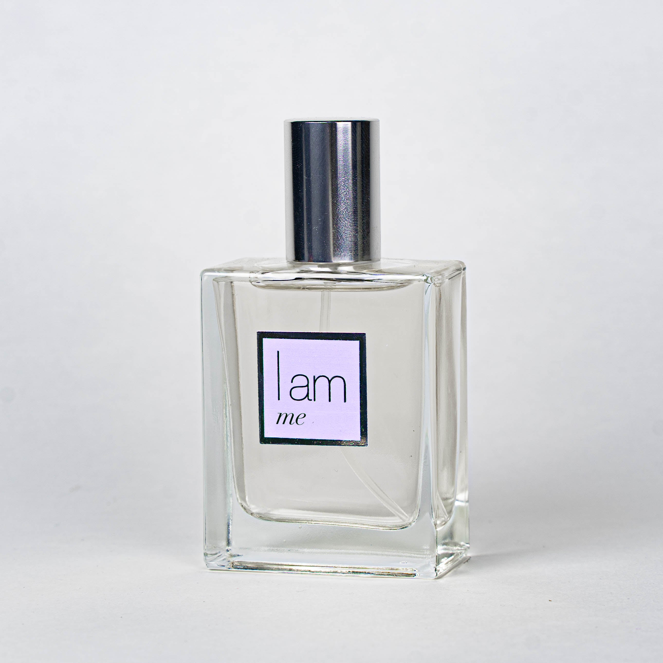 Clear perfume bottle with a silver cap on a white background