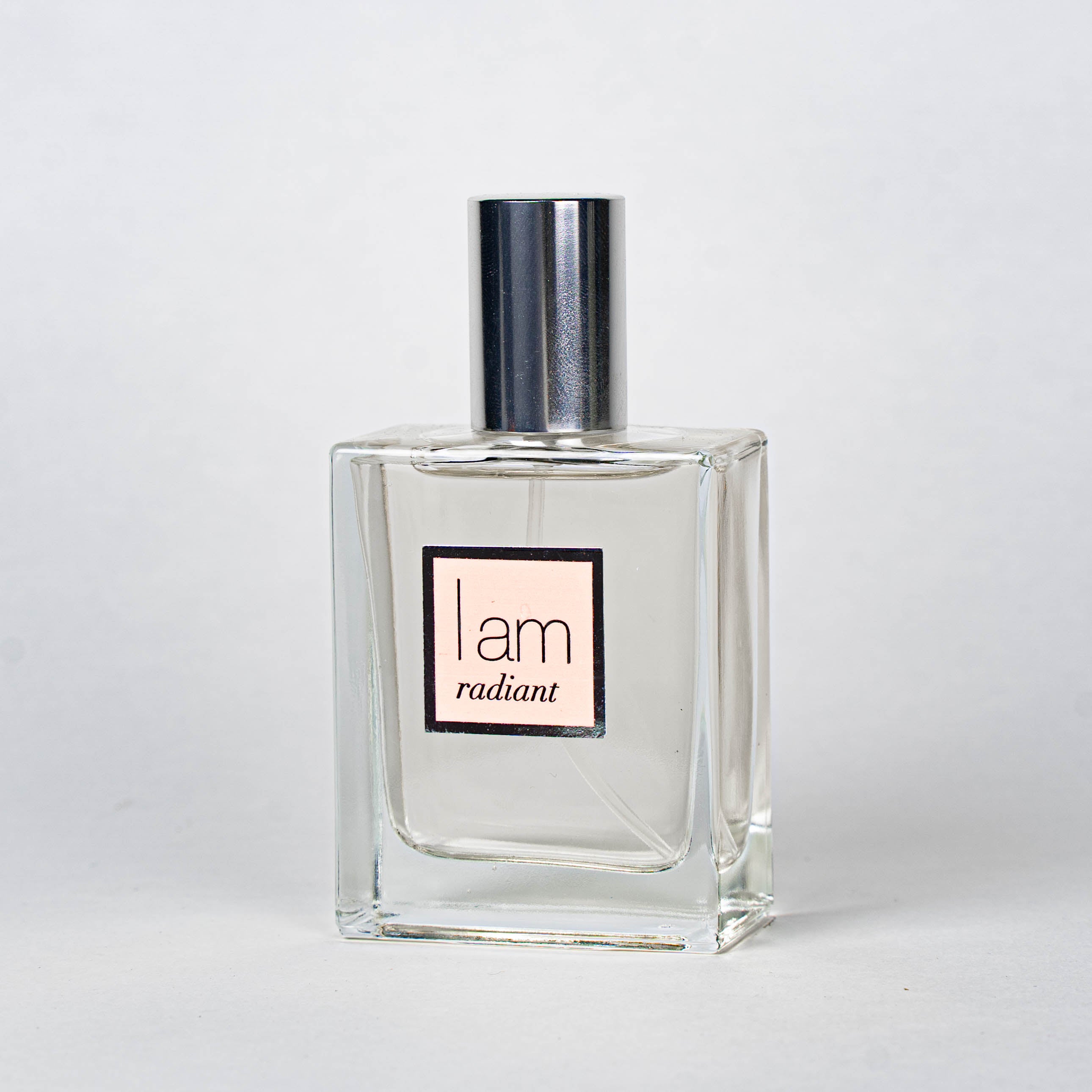 Clear perfume bottle with silver cap on a white background